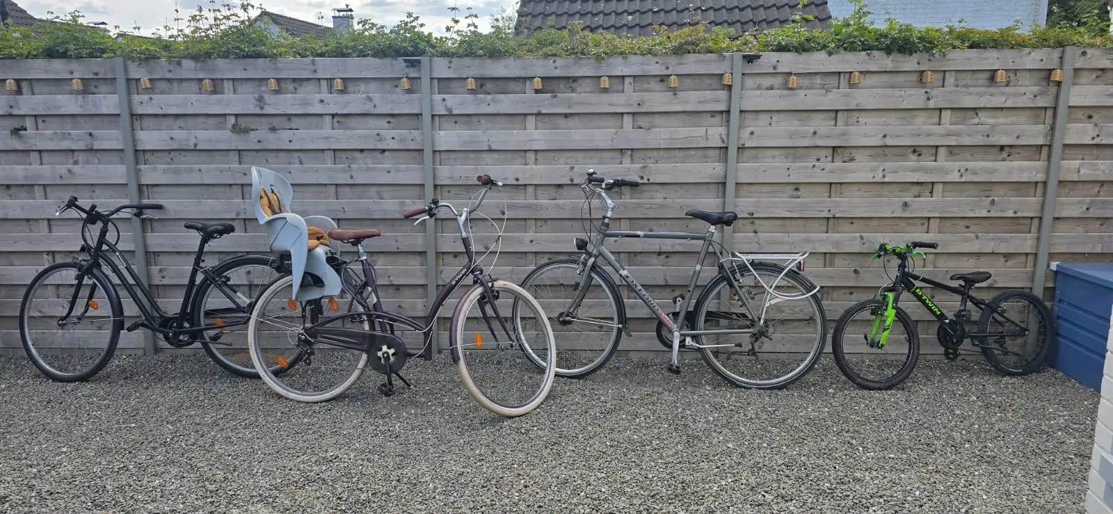 Fietsen bij de houten schutting, een met kinderzitje