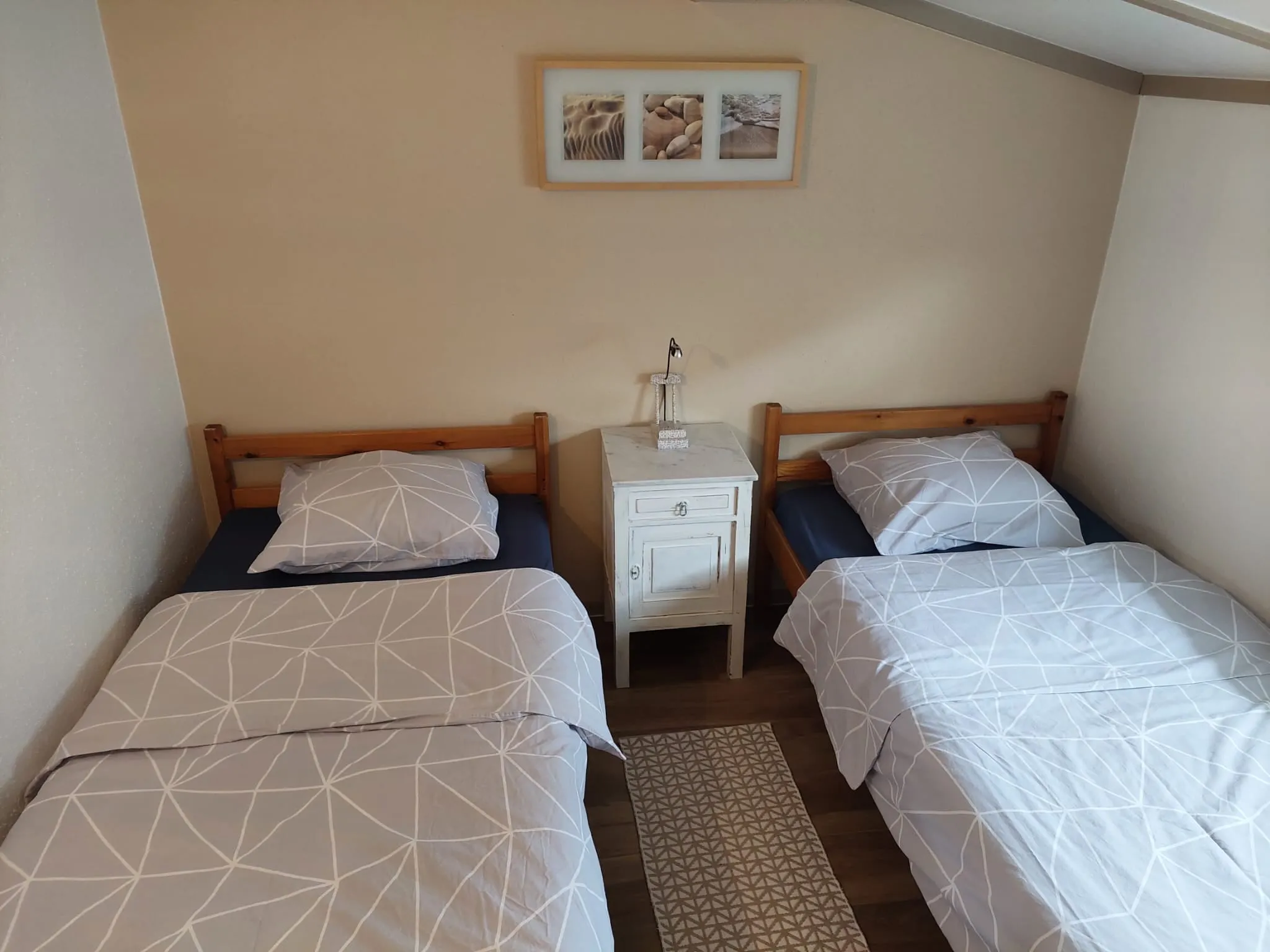 Slaapkamer met twee eenpersoonsbedden en een nachtkastje