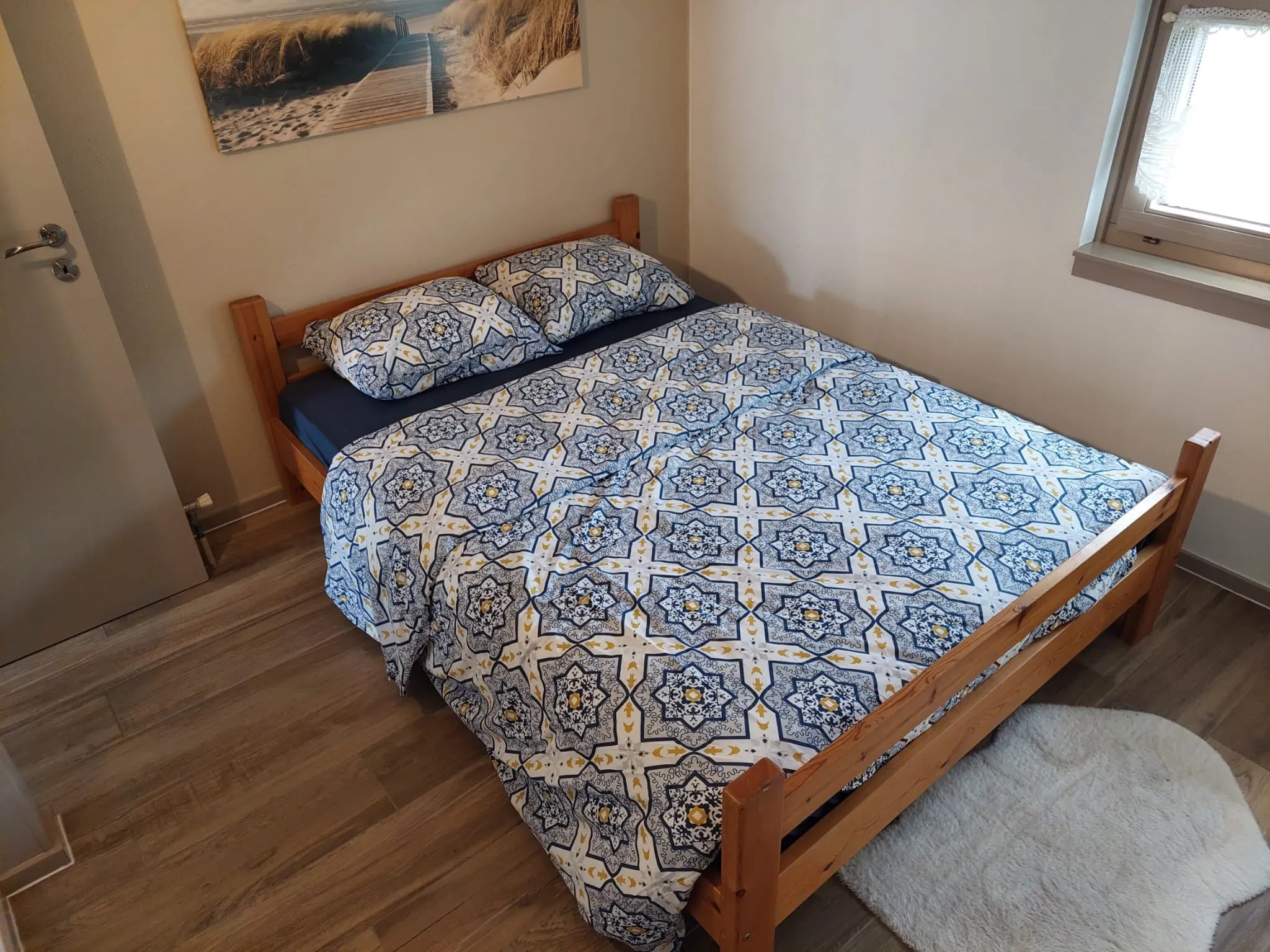 Schlafzimmer mit Doppelbett und blau-weißer Bettdecke