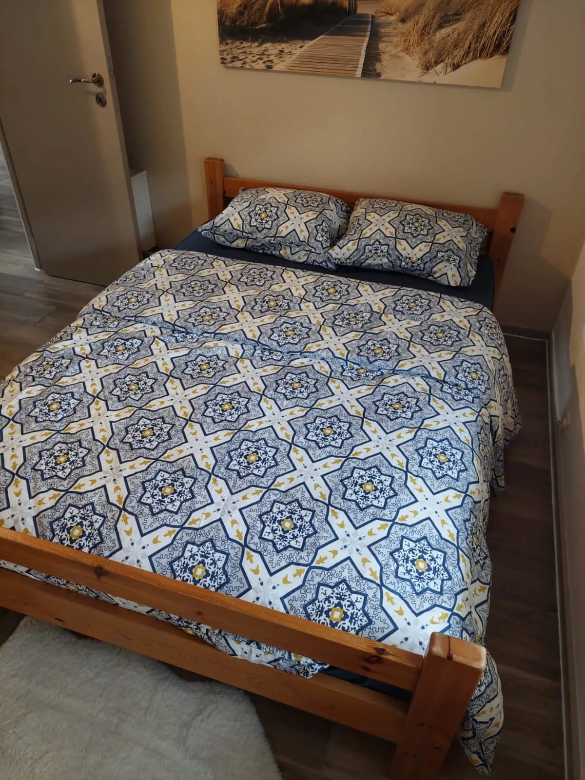 Doppelbett mit blau-weißem Bettbezug und zwei Kissen