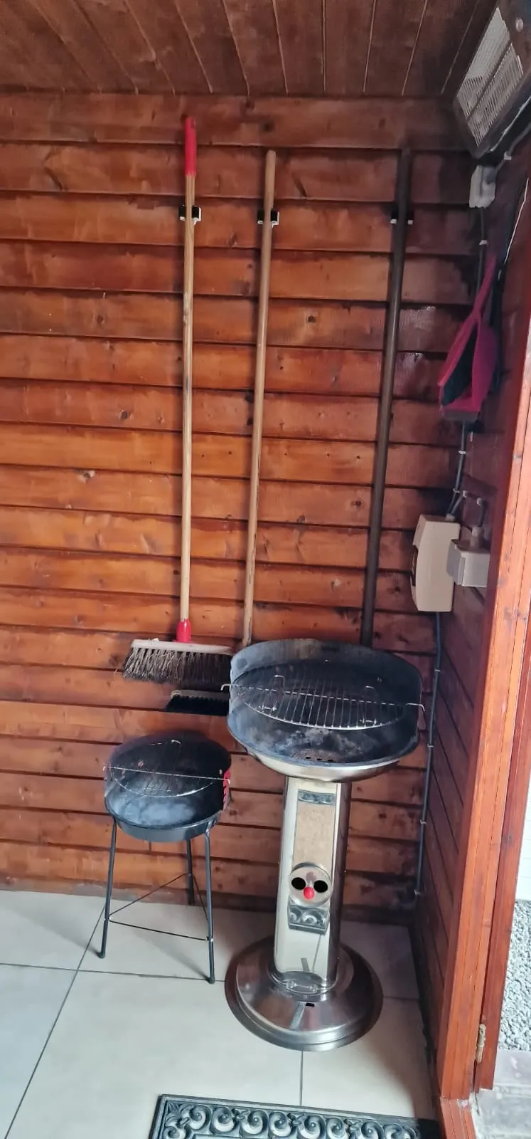 Gartenhaus mit einem Grill und einem Besen
