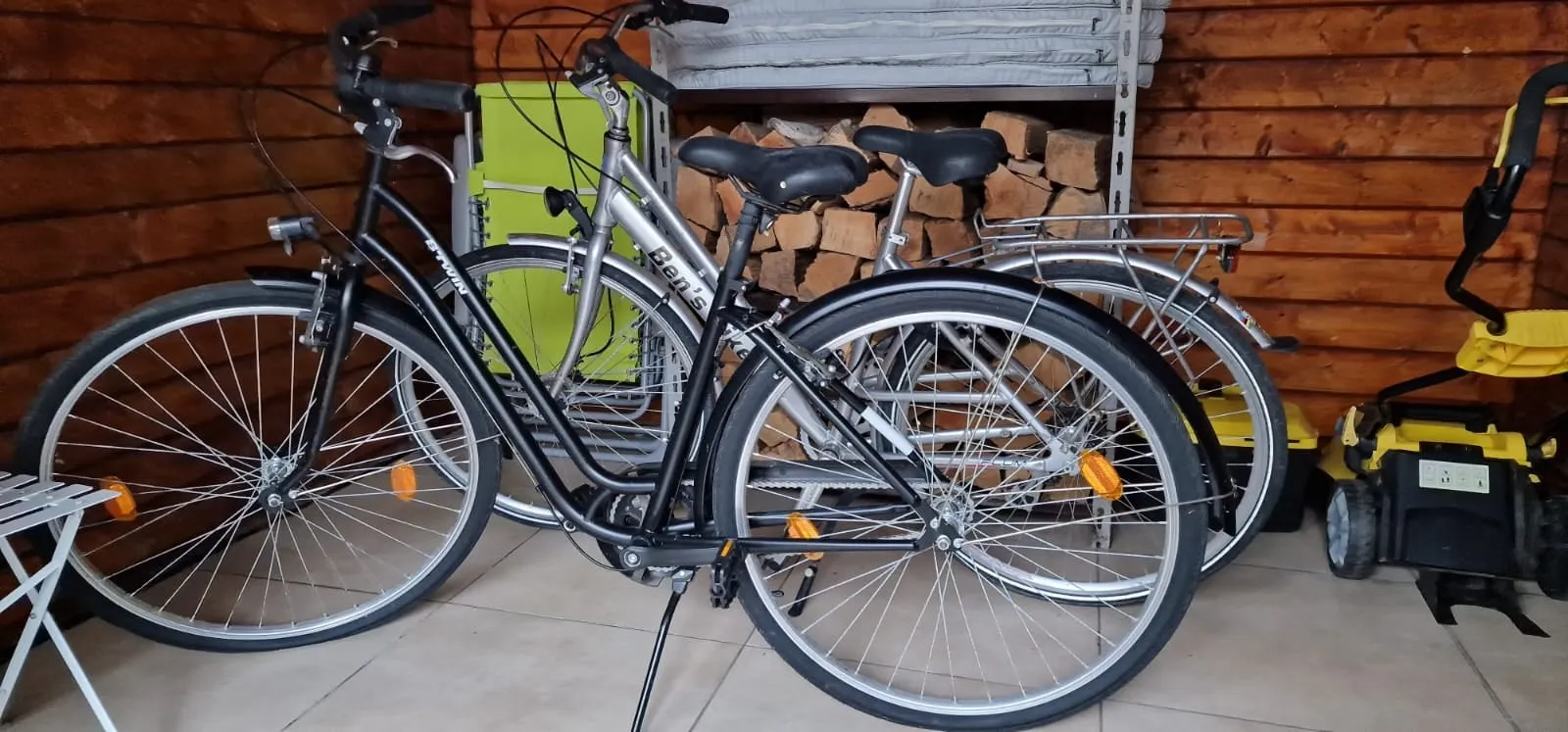 Zwei Fahrräder im Gartenhaus neben dem Brennholz