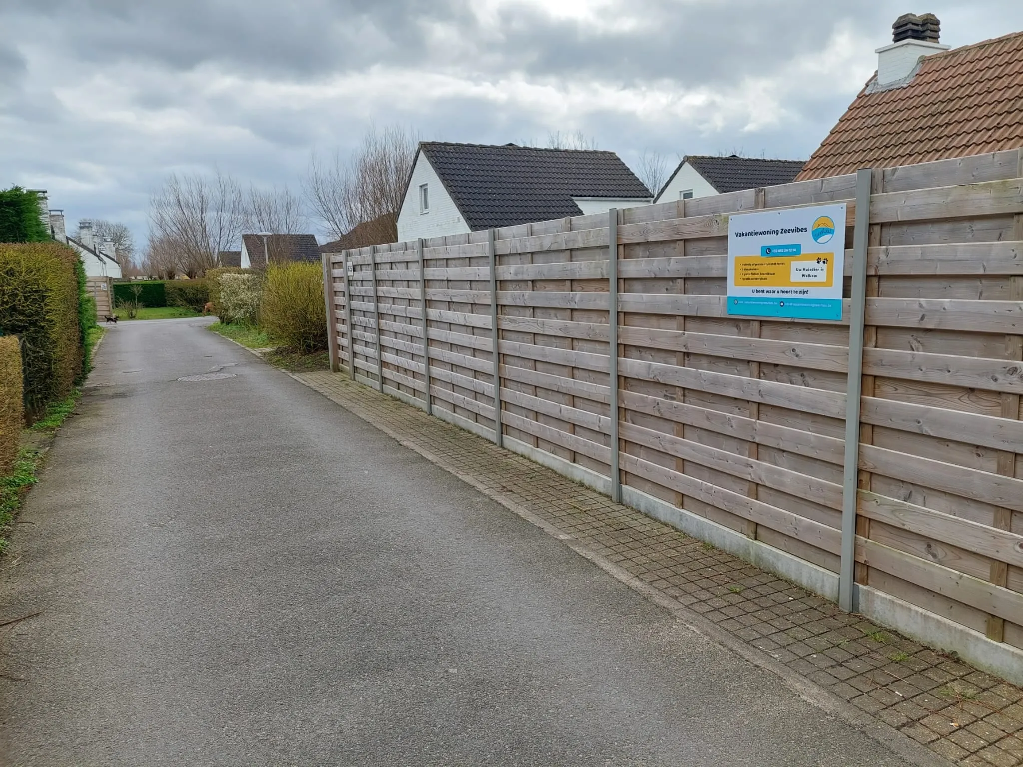 Die Straße entlang des Holzzauns des Hauses