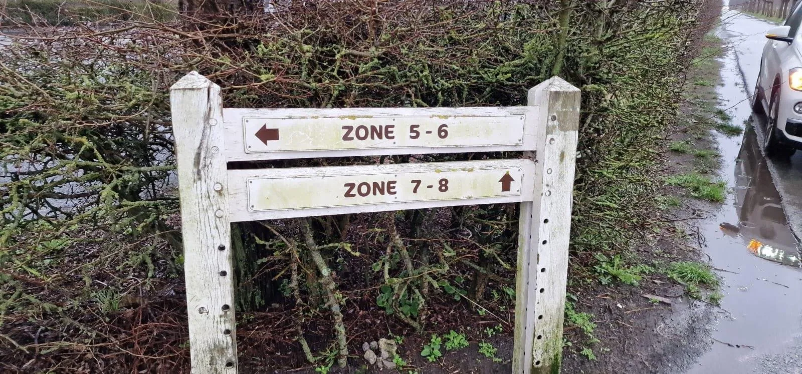 Houten bordje met de richtingen zone 5-6 en zone 7-8
